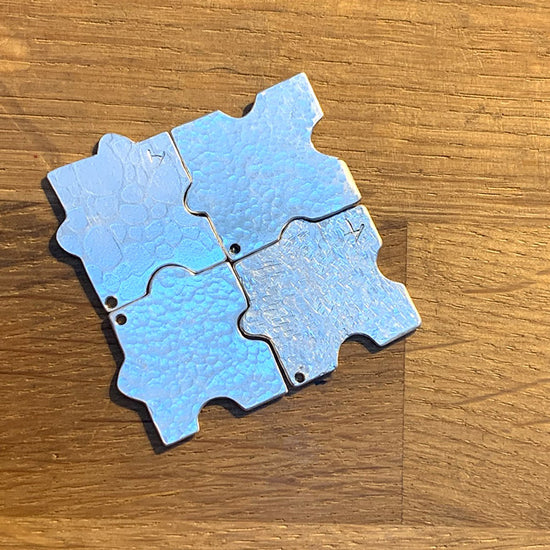 4 Pieces of a silver pendant created by a family so that all their pieces fit together. NI Silver jewellery making workshop.