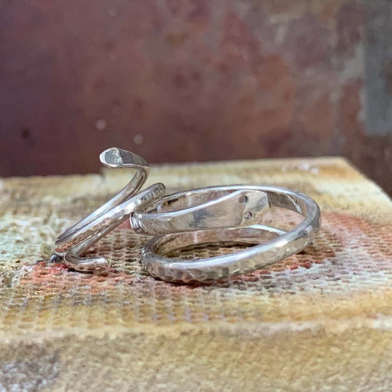 2 silver handmade rings with different textures on them