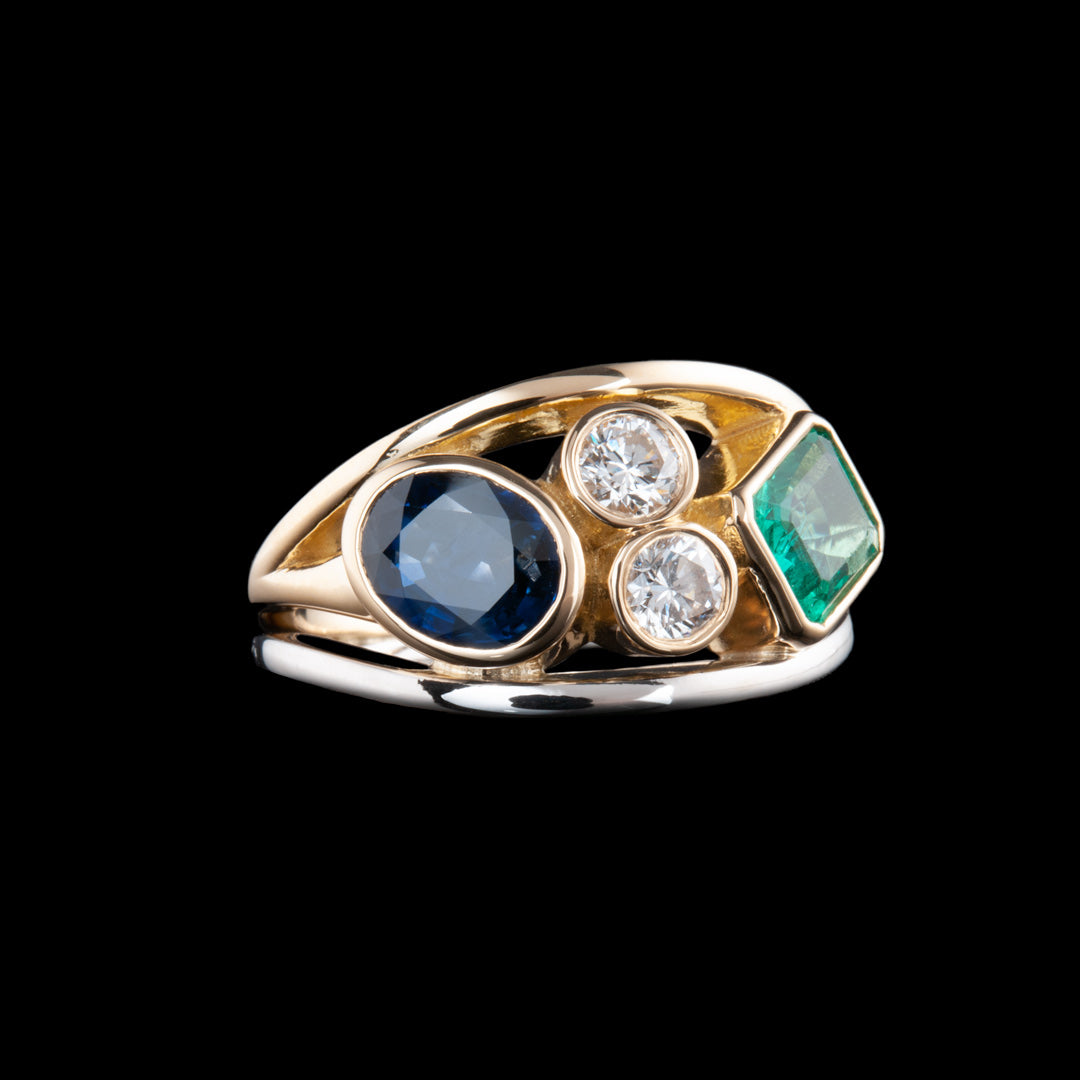 This amazing ring has platinum bottom ring, then has a middle ring which is holding a large oval sapphire, with 2 diamonds one on top of the other and then a square ruby. This lovely stones then have a gold ring across the top of them. A stunning bespoke ring creation by NI Silver jewellery.