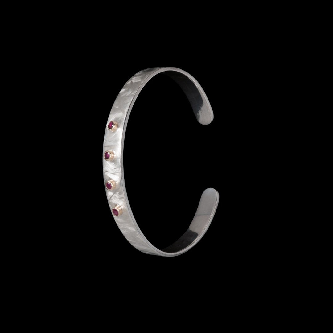 Solid silver bangle with gold mounts for 4 Ruby's. Hallmarked with our jewellery maker's mark. Contact NI Silver for any jewellery commissions.