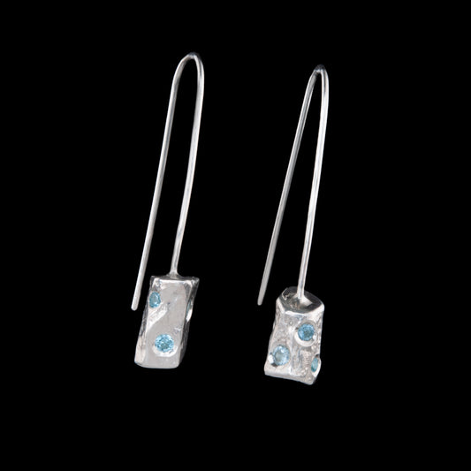 A pair of solid silver earrings with Aquamarine stones set into the free flowing shapes. The earrings do not have the normal backs, these are made from one piece of silver