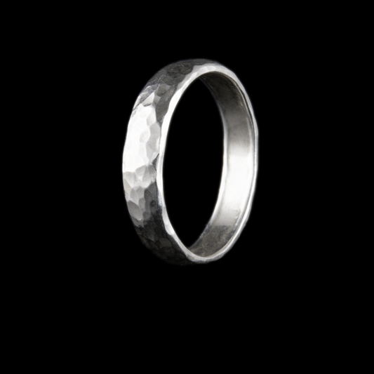 Silver ring inspired by the golf ball dimples, this ring has a textured surface, shown here aagainst a a black background.  3mm band of ring here.