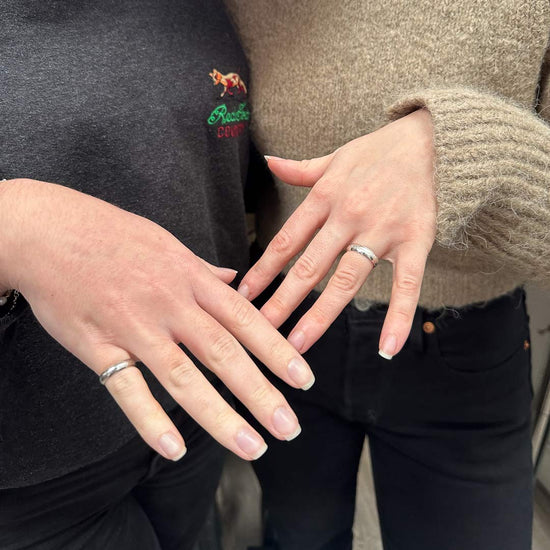 Shows 2 ladies' hands wearing their handmade silver textured rings made at NI Silver jewellery making experiences.