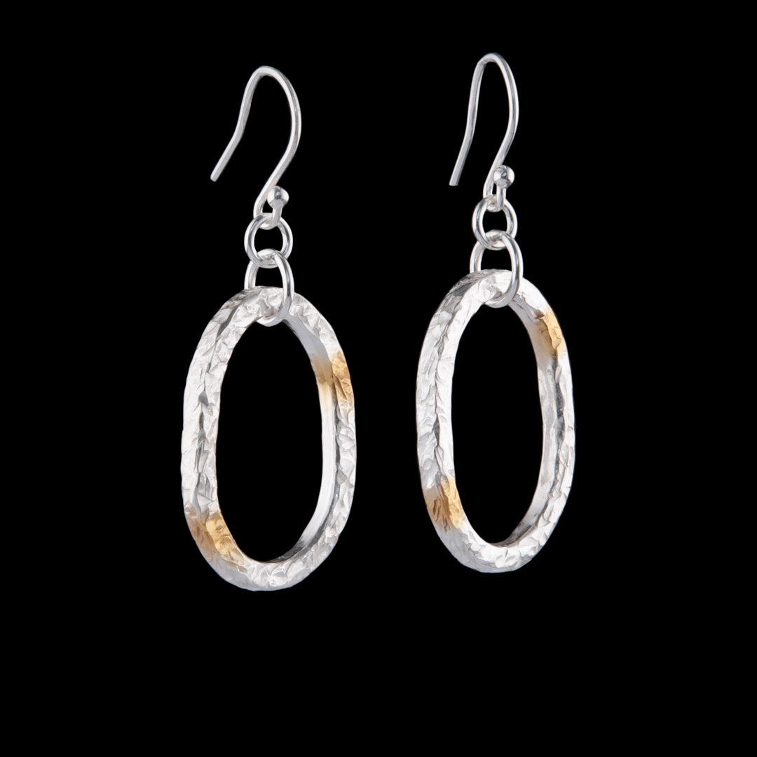 These silver earrings are shaped as the letter O and have been marked with Gold leaf at the 7 and 1 o'clock positions.