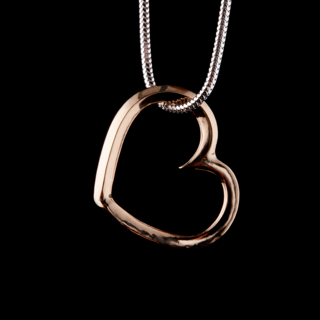 Gold Heart Necklace handmade from 9ct yellow gold. Hanging on a sterling silver snake chain.  By Northern Irish jewellery designer Ruth McEwan-Lyon