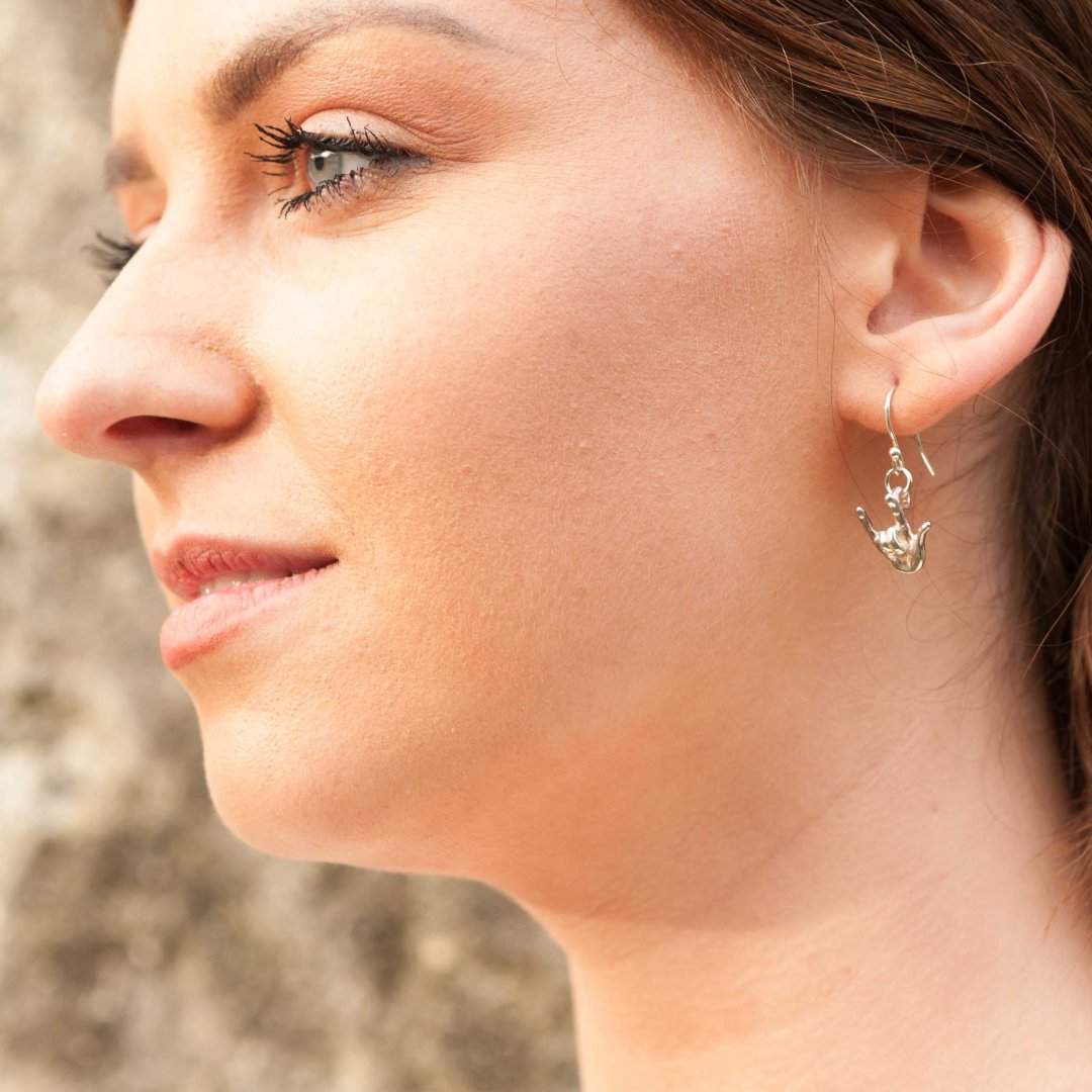 A lady wearing the Sign Language I Love You silver earrings. Hallmarked in UK.