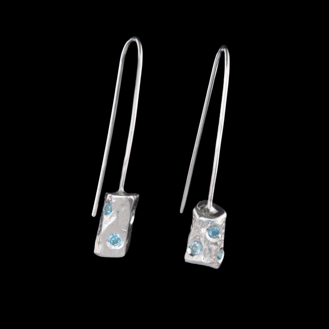 A pair of solid silver earrings with Aquamarine stones set into the free flowing shapes.  The earrings do not have the normal backs, these are made from one piece of silver 